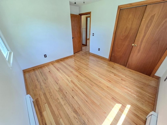 264 Dresser Hill Rd, Dudley, MA 01571 - unfurnished bedroom with baseboard heating, light wood-style floors, baseboards, and a closet