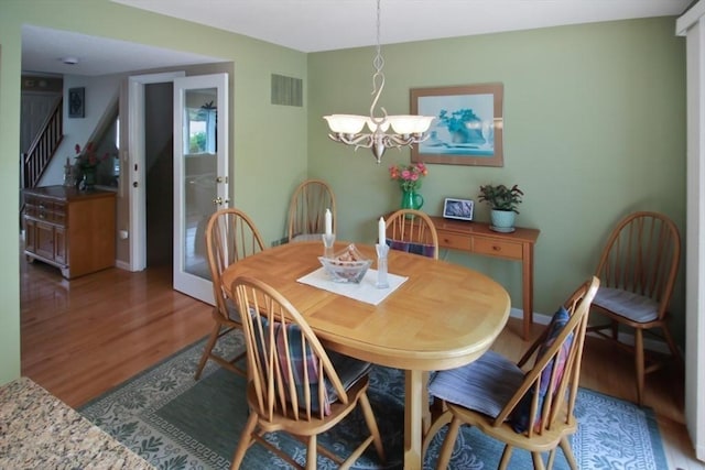 1504 Huckleberry Ct Unit 1504, Peabody, MA 01960 - dining area featuring a chandelier, wood finished floors, stairs, and baseboards