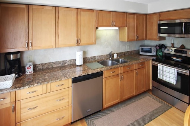 1504 Huckleberry Ct Unit 1504, Peabody, MA 01960 - kitchen featuring appliances with stainless steel finishes, a sink, dark stone counters, and light wood-style flooring