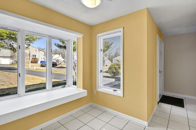 entryway featuring light tile patterned floors and baseboards