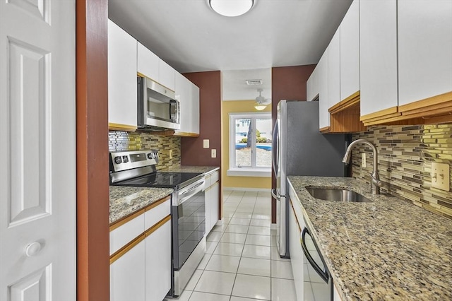 kitchen with visible vents, light tile patterned flooring, white cabinets, stainless steel appliances, and a sink