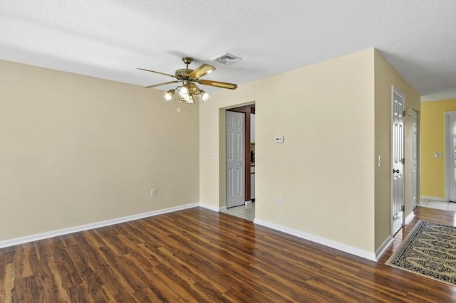 unfurnished room with visible vents, a textured ceiling, ceiling fan, and wood finished floors