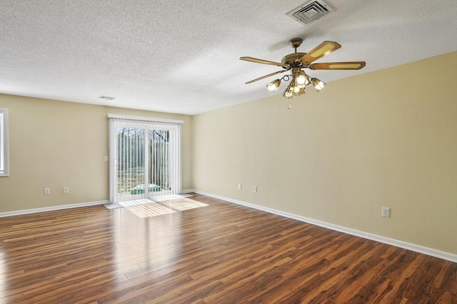 empty room with visible vents, baseboards, ceiling fan, and wood finished floors