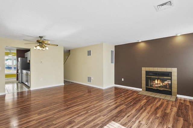 unfurnished living room with wood finished floors, visible vents, and ceiling fan