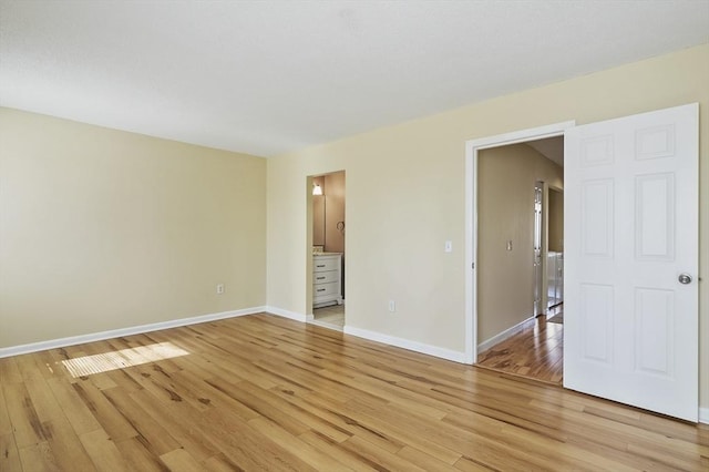 spare room with light wood-style floors and baseboards