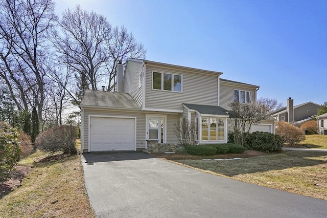 view of front of property with a garage, a chimney, and aphalt driveway