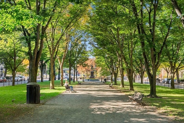 view of community featuring fence and a yard