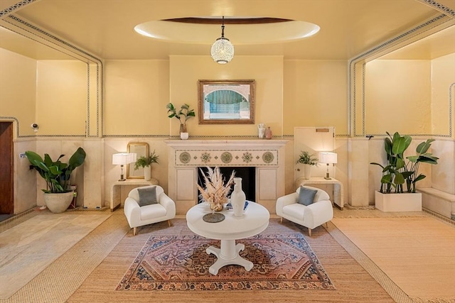 sitting room featuring a tray ceiling and a fireplace