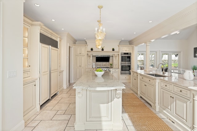 kitchen featuring a sink, paneled built in fridge, stainless steel double oven, and cream cabinetry