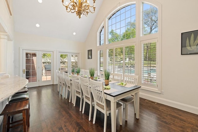 dining room featuring baseboards, a notable chandelier, high vaulted ceiling, and dark wood-style floors