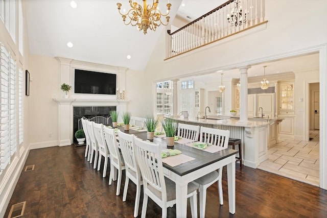 dining space featuring a fireplace, high vaulted ceiling, a chandelier, recessed lighting, and visible vents