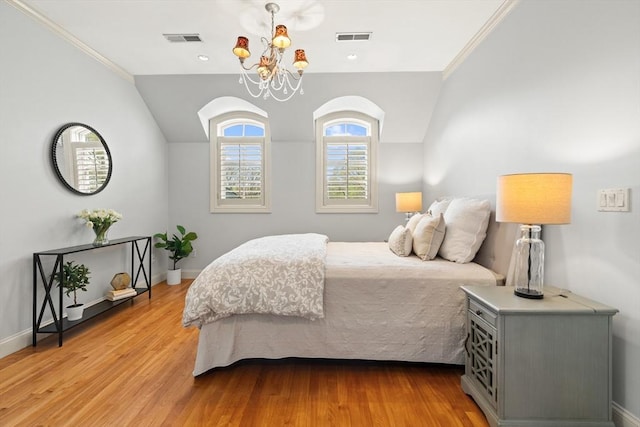 bedroom with a notable chandelier, visible vents, and light wood-style floors