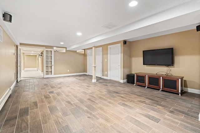 finished below grade area featuring visible vents, wood finished floors, baseboards, recessed lighting, and a baseboard heating unit
