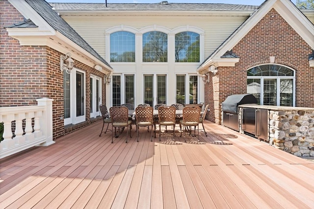 wooden deck featuring grilling area, exterior kitchen, and outdoor dining space