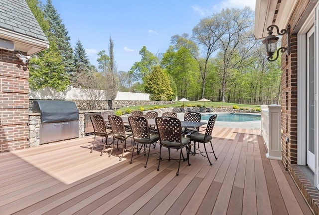 wooden deck featuring a fenced in pool, a fenced backyard, outdoor dining area, and area for grilling