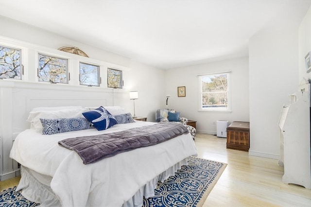 bedroom with light wood-type flooring and baseboards