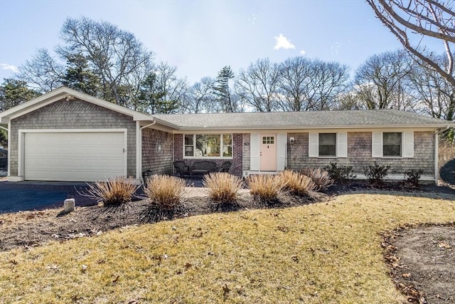 ranch-style home with driveway, a front yard, and a garage