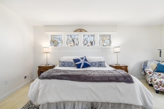 bedroom featuring baseboards and light wood finished floors