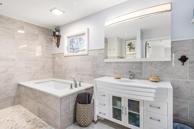 bathroom featuring vanity, tile walls, and a garden tub