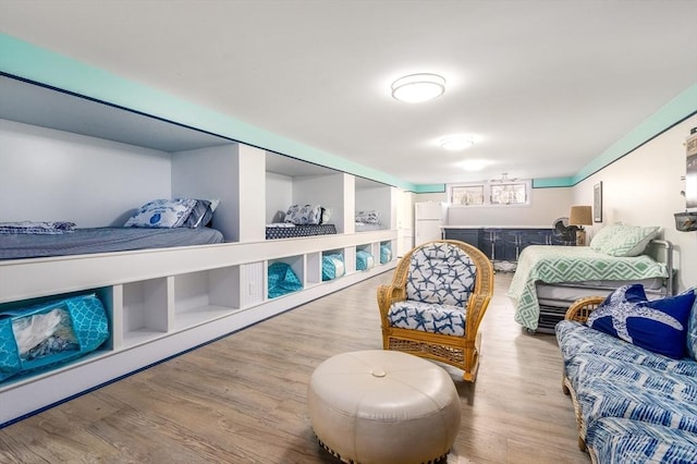 bedroom with wood finished floors and freestanding refrigerator