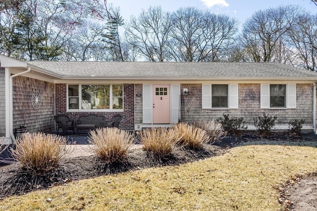 single story home with a shingled roof and a front yard