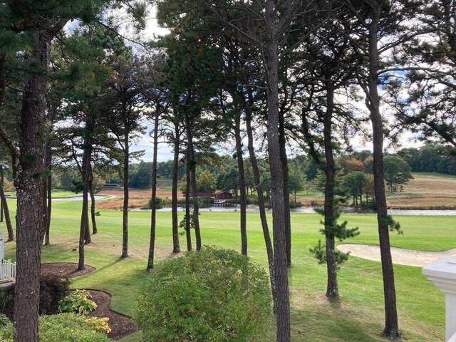 surrounding community featuring a water view and a lawn