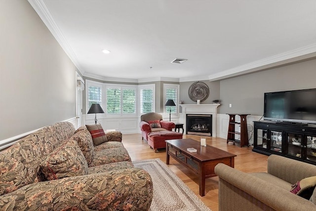 4 Sterling Hill Ln Unit 424, Exeter, NH 03833 - living room with ornamental molding, a glass covered fireplace, light wood-type flooring, a wainscoted wall, and recessed lighting
