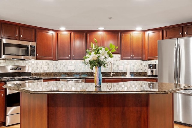 4 Sterling Hill Ln Unit 424, Exeter, NH 03833 - kitchen with appliances with stainless steel finishes, dark stone countertops, decorative backsplash, a kitchen island, and recessed lighting