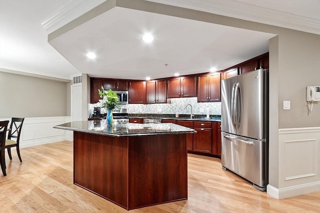 4 Sterling Hill Ln Unit 424, Exeter, NH 03833 - kitchen with stainless steel appliances, a center island, crown molding, light wood finished floors, and wainscoting