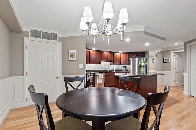 4 Sterling Hill Ln Unit 424, Exeter, NH 03833 - dining space with a chandelier, light wood-style flooring, ornamental molding, a decorative wall, and wainscoting