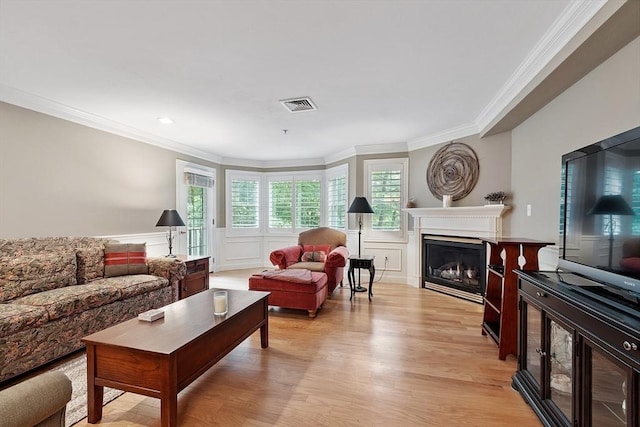 4 Sterling Hill Ln Unit 424, Exeter, NH 03833 - living area featuring ornamental molding, a fireplace, light wood-type flooring, a decorative wall, and wainscoting