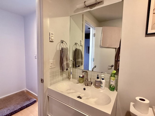 bathroom with vanity, baseboards, and tasteful backsplash