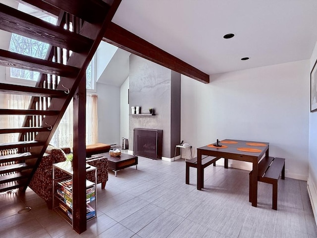 interior space featuring lofted ceiling with beams, a fireplace, and baseboards