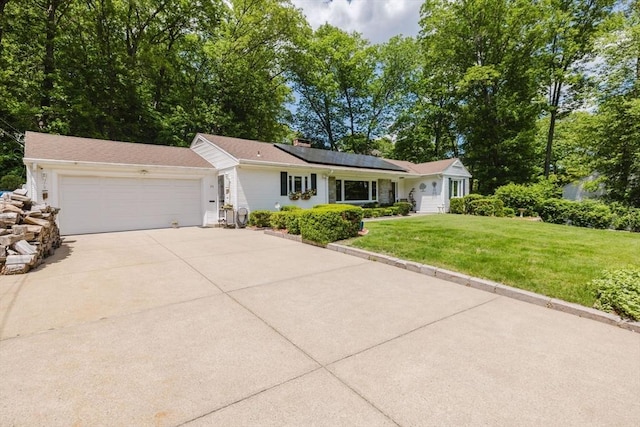 35 Williams St, Lincoln, RI 02865 - single story home featuring a front lawn, a garage, roof mounted solar panels, concrete driveway, and a chimney