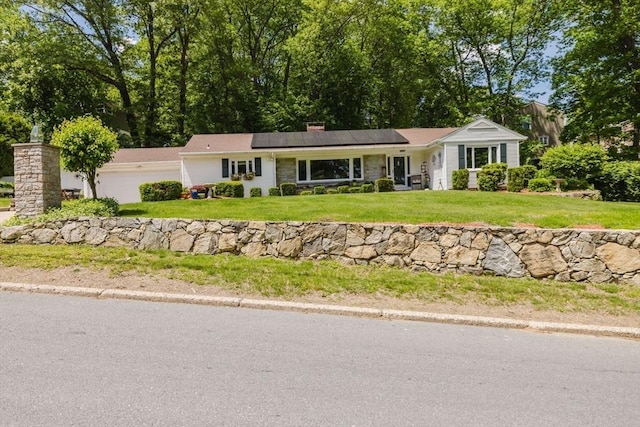 35 Williams St, Lincoln, RI 02865 - ranch-style house with roof mounted solar panels, a front yard, an attached garage, and a chimney