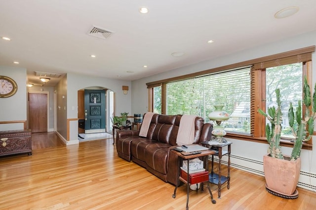 35 Williams St, Lincoln, RI 02865 - living room featuring arched walkways, light wood-type flooring, recessed lighting, baseboards, and a baseboard radiator