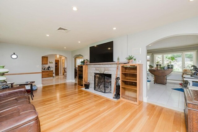 35 Williams St, Lincoln, RI 02865 - living area featuring a fireplace, light wood-style floors, recessed lighting, arched walkways, and baseboards
