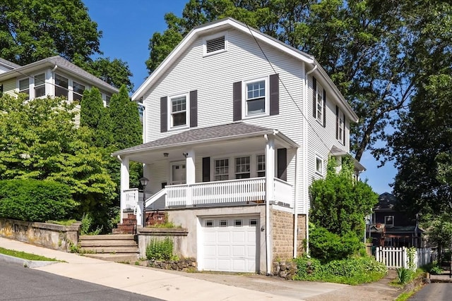 15 Newland Rd, Arlington, MA 02474 - view of front of house featuring an attached garage, covered porch, concrete driveway, and stairway