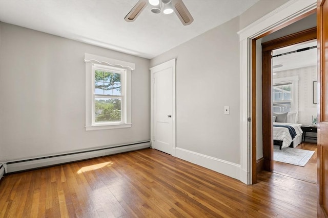 15 Newland Rd, Arlington, MA 02474 - unfurnished bedroom with a baseboard heating unit, wood finished floors, and a ceiling fan