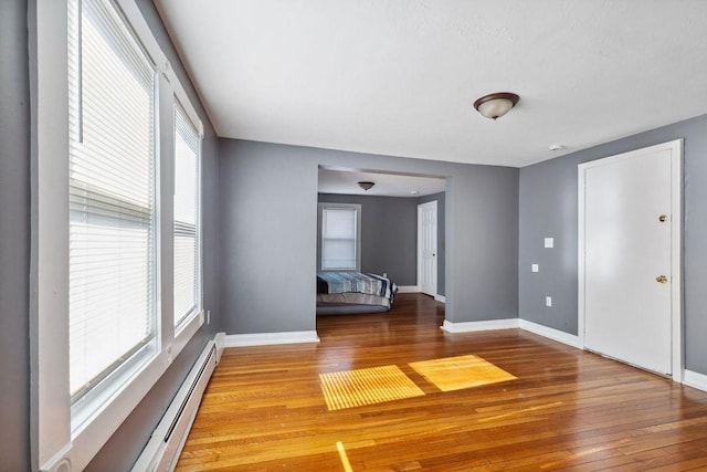 interior space featuring baseboard heating and light hardwood / wood-style flooring