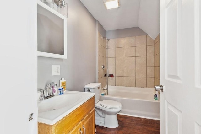 full bathroom featuring hardwood / wood-style flooring, toilet, vanity, and tiled shower / bath