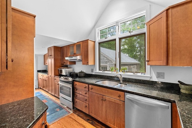 146 Chief Justic Cushing Hwy, Scituate, MA 02066 - kitchen featuring stainless steel appliances, under cabinet range hood, light wood-type flooring, vaulted ceiling, and brown cabinets