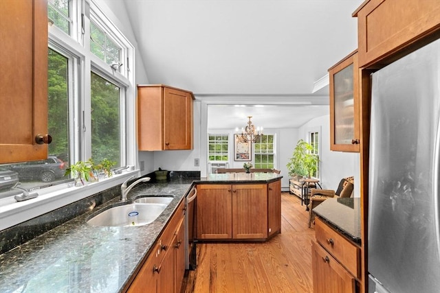 146 Chief Justic Cushing Hwy, Scituate, MA 02066 - kitchen featuring appliances with stainless steel finishes, light wood-style floors, dark stone counters, a chandelier, and a peninsula