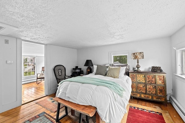 146 Chief Justic Cushing Hwy, Scituate, MA 02066 - bedroom with a baseboard radiator, a textured ceiling, hardwood / wood-style flooring, and a baseboard heating unit