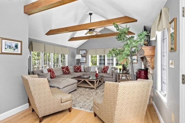 living room with ceiling fan, lofted ceiling with beams, baseboards, and light wood-style floors