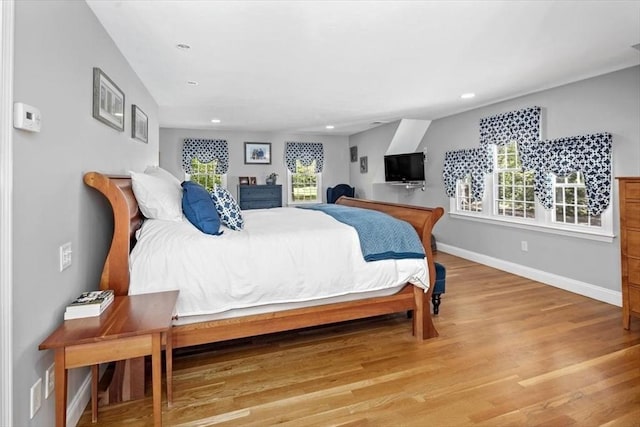 bedroom featuring baseboards, multiple windows, recessed lighting, and light wood-style flooring