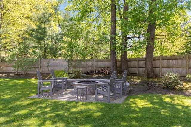 view of yard with a fenced backyard, a fire pit, and a patio area