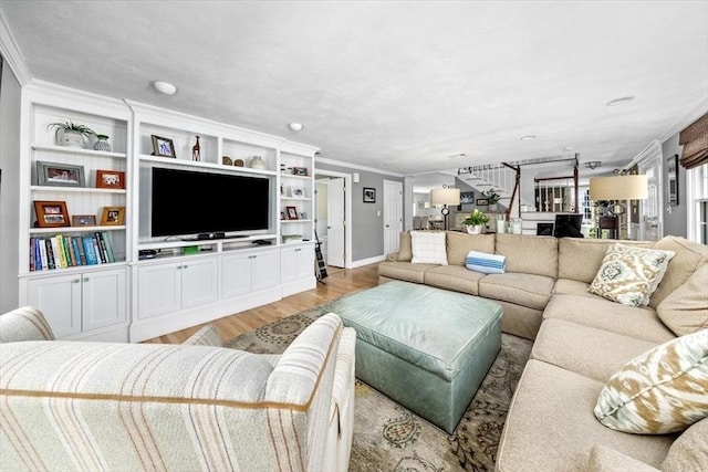 living area featuring crown molding, baseboards, and light wood-type flooring