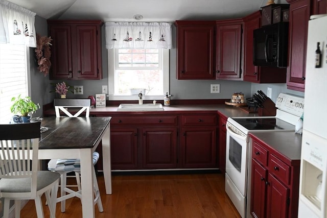 72 Lakeview Pl, Taunton, MA 02780 - kitchen with white range with electric cooktop, black microwave, reddish brown cabinets, dark wood finished floors, and dark countertops