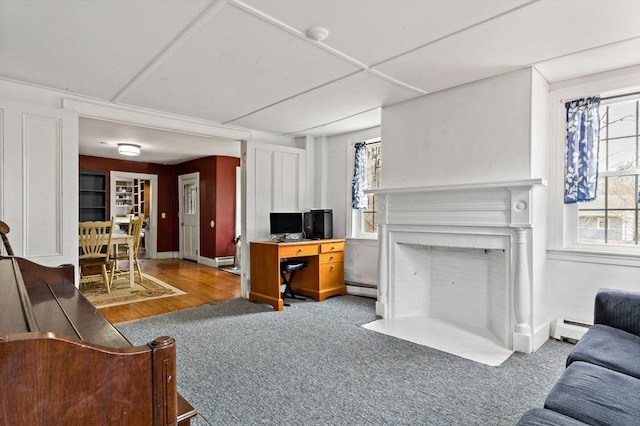 living area featuring a fireplace with flush hearth, baseboard heating, and carpet floors